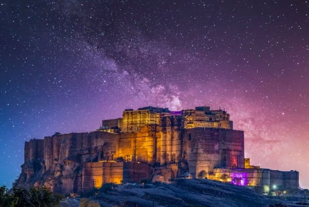 Mehrangarh Fort in Jodhpur lit up at night under the Milky Way