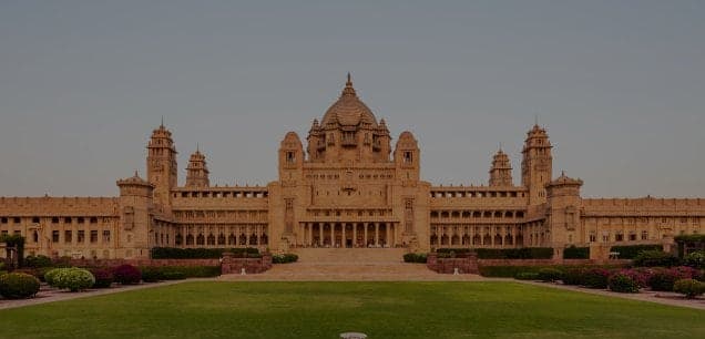 Umaid Bhawan Palace in Jodhpur at dusk, across its front lawn
