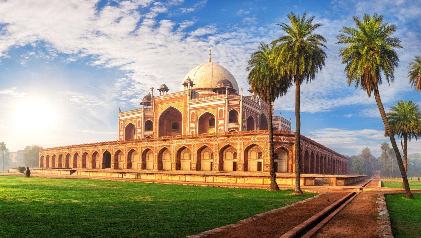 Humayun's Tomb in Delhi, framed by palm trees and green lawns